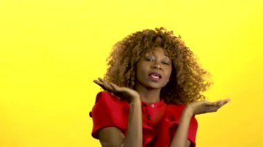 Melez kız atlama ve müzik ile eğleniyor. Sarı arka plan. Ağır çekim