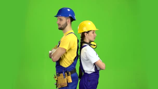 Twee bouwers staan rug aan rug en wijs met hun vingers rechte. Groen scherm — Stockvideo
