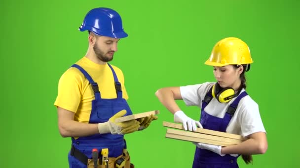 Pair of builders choose wooden boards. Green screen — Stock Video