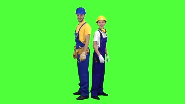 Dos constructores se paran hacia atrás y señalan con los dedos rectos. Pantalla verde. Movimiento lento — Vídeo de stock