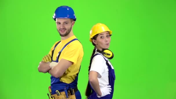 Ürün touting kız adamla inşaatçılar ve onların başparmak sırıtmak. Yeşil ekran. Ağır çekim — Stok video