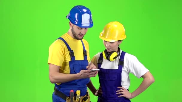 Le gars que le constructeur montre l'horaire au téléphone. Écran vert. Mouvement lent — Video