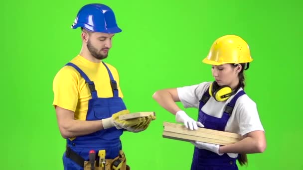 Paar bouwers Kies houten planken. Groen scherm. Slow motion — Stockvideo