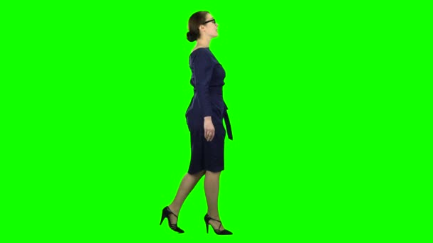 ビジネス女性が歩いて、彼女の友達に手を振っています。緑色の画面。横から見た図 — ストック動画