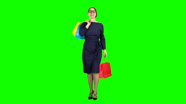 Girl with shopping packages in her hands is walking along the street. Green screen — Stock Video