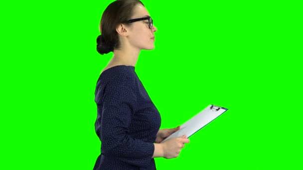 İş kadını sokakta bir kağıt tablet ile gelir. Yeşil ekran. Yan görünüm — Stok video