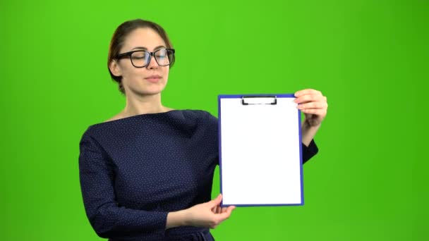 Girl raises a paper tablet and smiles. Green screen — Stock Video