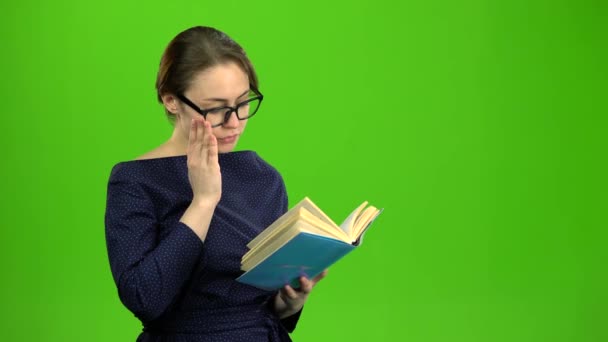 A rapariga inteligente está a ler um livro. Tela verde — Vídeo de Stock