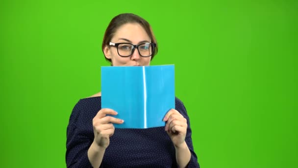 スマートな女の子は、本を読んでいます。緑色の画面 — ストック動画