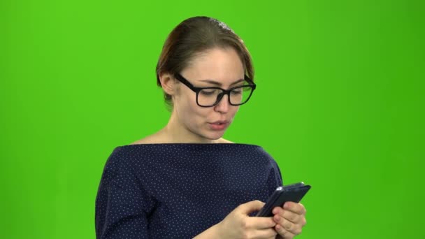 携帯電話を保持している少女は、メッセージとペースをダイヤルします。緑色の画面 — ストック動画