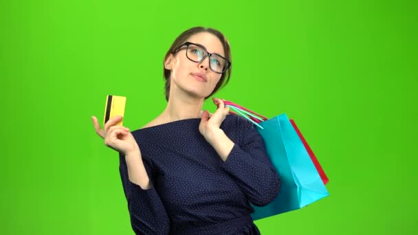 Жінка з паперовими пакетами йде за покупками з карткою в руках. Зелений екран — стокове відео