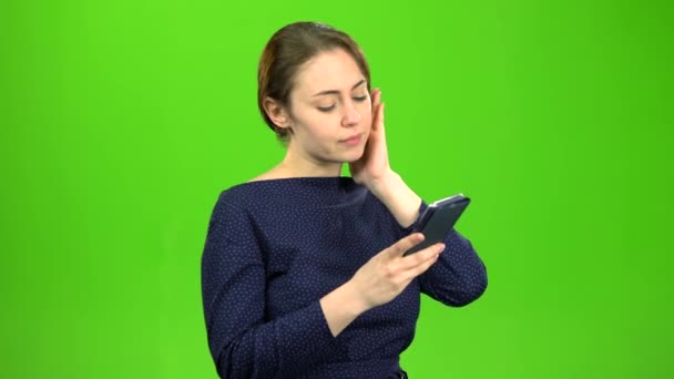 Menina segurando um telefone marca uma mensagem e passos. Tela verde — Vídeo de Stock