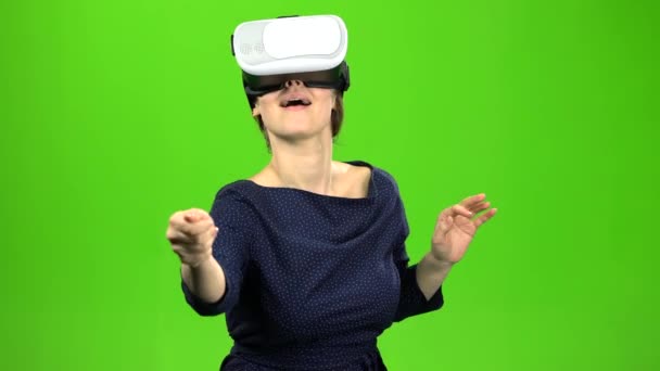 Woman in virtual glasses is watching an interesting film. Green screen — Stock Video