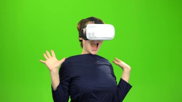 Woman in virtual glasses is watching an interesting film. Green screen — Stock Video