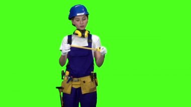 Oluşturucu bir mezura yardımıyla ölçümleri alır. Yeşil ekran. Ağır çekim