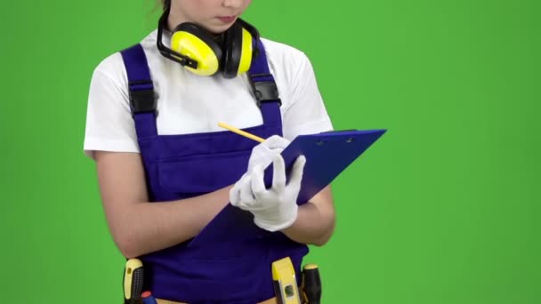 Worker records the measurement data in a blue tablet. Green screen. Slow motion. Close up — Stock Video