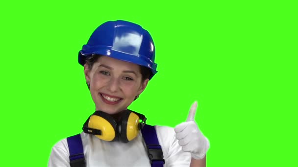 Építő lány megmutatja remek és mosolyog. Zöld képernyő. Lassú mozgás — Stock videók