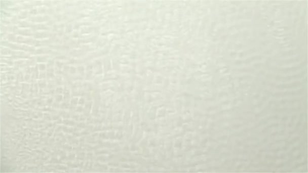 Wavy surface of water caused by sound vibrations. White background. Slow motion — Stock Video