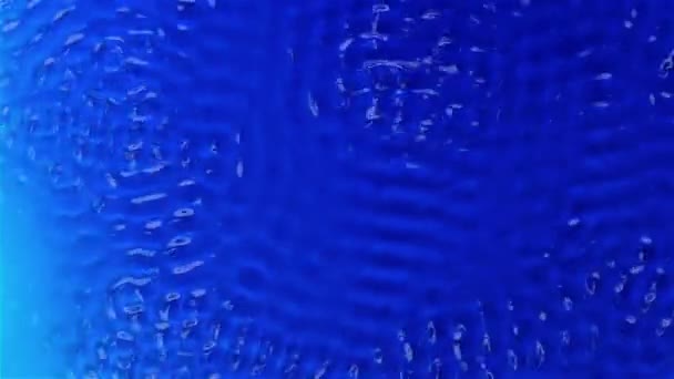 Water onder invloed van trillingen creëert grafische texturen. Blauwe achtergrond. Slow motion — Stockvideo