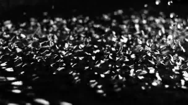 Excitation de la surface de l'eau par les fréquences ultrasonores. Fond noir. Mouvement lent 