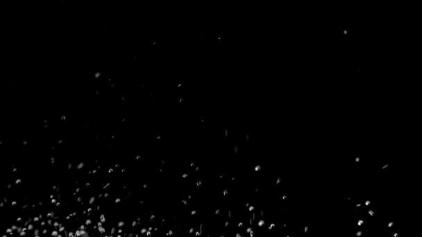 Des gouttes d'eau sous forme de boules se lèvent. Fond noir. Mouvement lent 