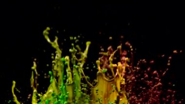 Çok renkli su jetleri vur. Siyah arka plan. Ağır çekim