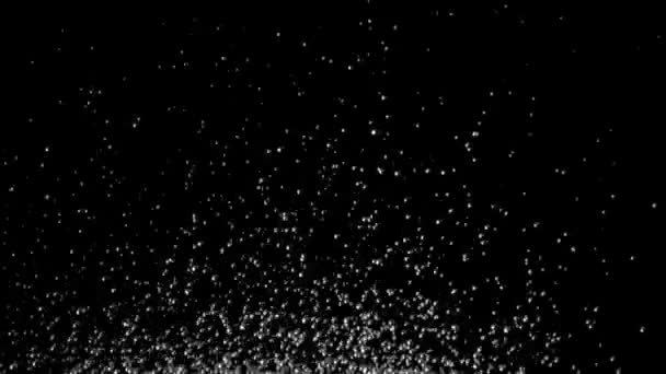 Opwinding van het water gooit honderden druppels omhoog. Zwarte achtergrond. Slow motion — Stockvideo