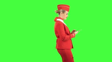 Kadın telefonla adımlar ve bir ileti yazar. Yeşil ekran. Yan görünüm