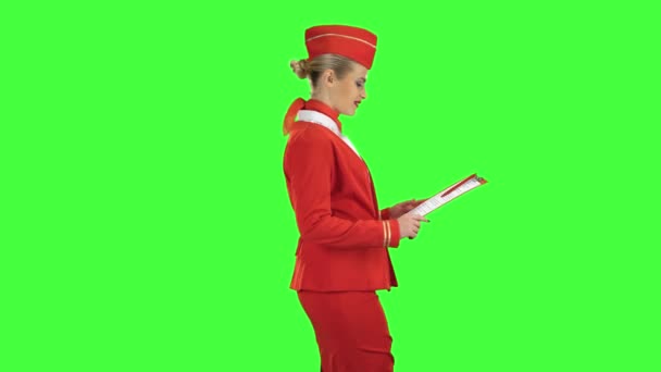 Woman steps along with a red folder in her hands. Green screen. Side view — Stock Video