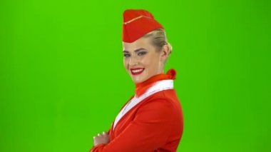 Hostes Kırmızı elbiseli küçük bir flört kırpmak. Yeşil ekran. Yan görünüm