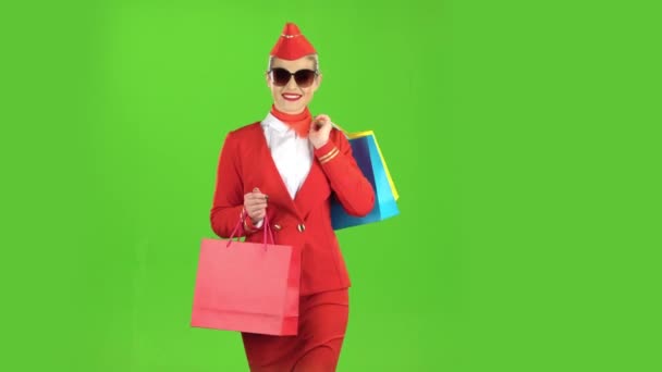 Chica en sunglassesis viene con bolsas de compras. Pantalla verde — Vídeos de Stock