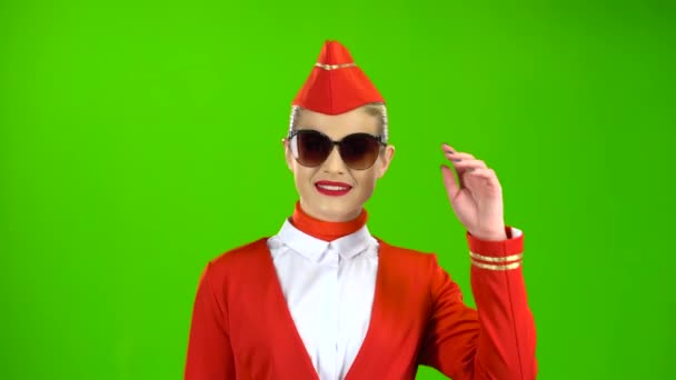 La hostess in abito rosso si toglie gli occhiali da sole. Schermo verde — Video Stock