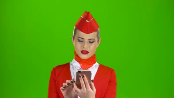 Κορίτσι με το κόκκινο ένδυμα, βλέπουν στο τηλέφωνο flipping μέσα από τις εικόνες. Πράσινη οθόνη — Αρχείο Βίντεο