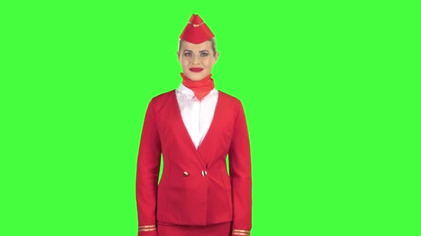 Stewardess in een rood pak knipoogt een lichte flirt stuurt een kus van de lucht. Groen scherm — Stockvideo