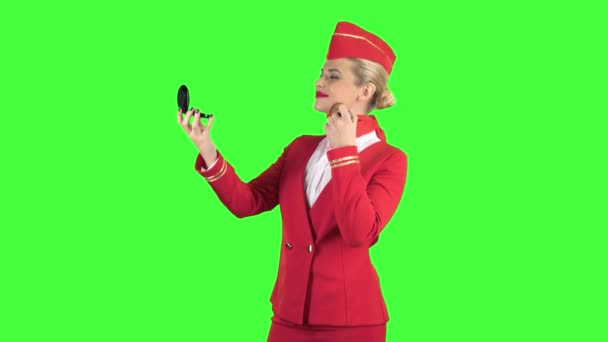 Stewardess looks in the mirror and paints her face with a tassel. Green screen — Stock Video