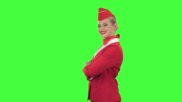 Flygvärdinna i röd kostym blinkningar en liten flirt. Grön skärm. Sidovy — Stockvideo