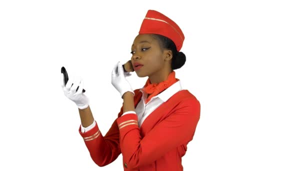 Αεροσυνοδός αφρο αμερικανικό κοιτάζει στον καθρέφτη και ζωγραφίζει το πρόσωπό της με κοκκινίζει. Κανάλι άλφα — Αρχείο Βίντεο