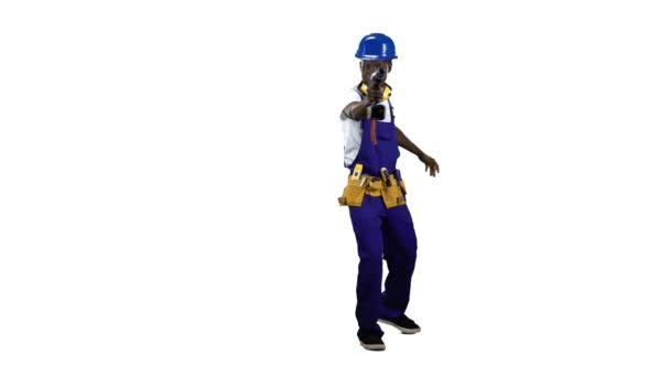 El hombre afroamericano que trabaja en una obra de construcción viene con un taladro en sus manos. Canal alfa — Vídeos de Stock