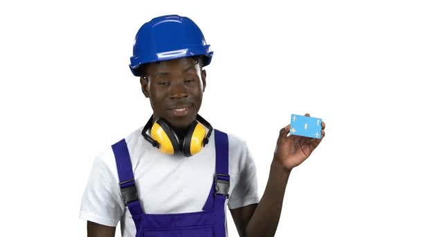 African American builder lifts blue card and shows thumbs up. Alpha channel — Stock Video