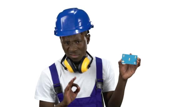 African American builder lifts blue card and shows thumbs down . Alpha channel — Stock Video