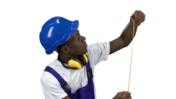 Οικοδόμος Αφρικανικός Αμερικανός αναλαμβάνει μετρήσεις με ένα κίτρινο μετροταινία. Κανάλι άλφα — Αρχείο Βίντεο