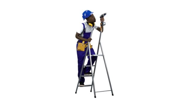 Builder in a helmet with a drill in his hands climbs the stairs . Alpha channel — Stock Video