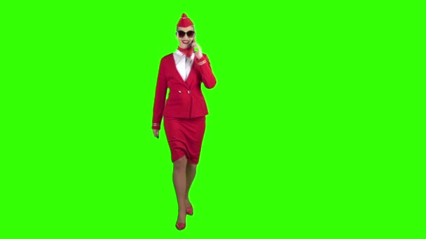 Stewardess in een rood pak spreekt op de telefoon en een steenworp afstand. Groen scherm. Slow motion — Stockvideo