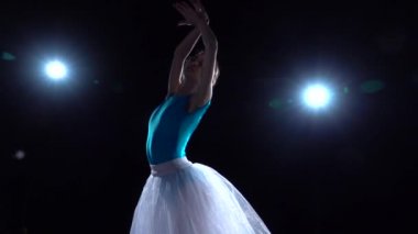 Beyaz etekli balerin klasik bale gösterisi yapıyor. Ağır çekim. Kapat..