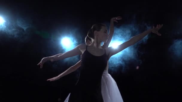 흰색 과 검은색 의 투투 새 의부드러운 발레리나 가 춤을 추고 있다. 가까이, 느린 동작. — 비디오