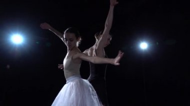 Dansta dönen siyah ve beyaz etekli mükemmel balerinler. Yaklaşın, ağır çekim..