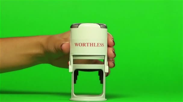 White stamp WORTHLESS on a green background. Close up. Green screen — Stock Video