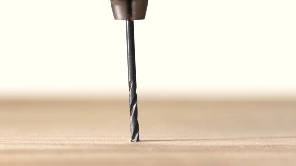 Perceuse sur plaque de bois, sur blanc, au ralenti 