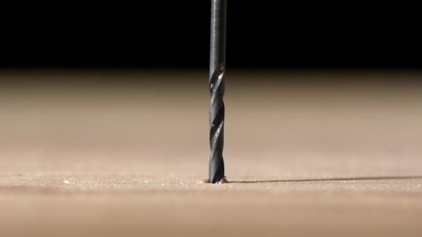 Perceuse sur plaque de bois, sur blanc, au ralenti, gros plan 