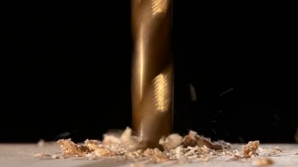 Drill with sawdust on wooden plate black, close up — Stock Video